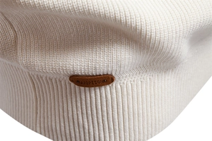 Detailed macro shot of white ribbed knit fabric with premium leather logo patch