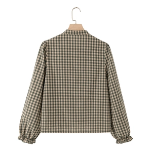 Detail eines karierten Langarmhemds mit Rüschendetails und grau-grünem Karomuster