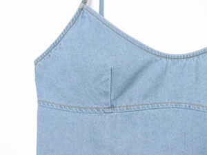 Detailaufnahme der Nähte und Denim-Textur auf einem hellblauen Schleifen-Top