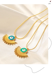 Detailed macro view of gold-plated fan-shaped evil eye pendants on white silk