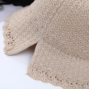 Macro shot of beige knitted sun hat showing delicate lace hollow edges and split brim detail