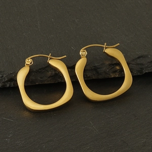 Detail of 18k gold-plated irregular square wave earrings on dark textured stone