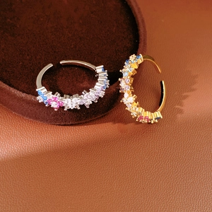 Detailed close-up of adjustable flower rings with colorful zircon stones in gold and silver
