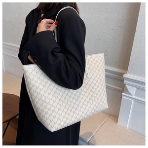 Dettaglio della borsa tote crema alla moda con motivo monogramma marrone e pelle PU
