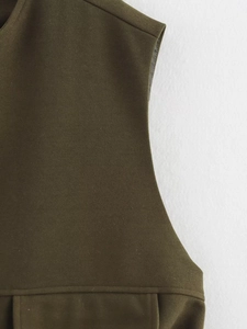 Detailed close-up of dark olive green sleeveless top showing woven fabric texture and stitching