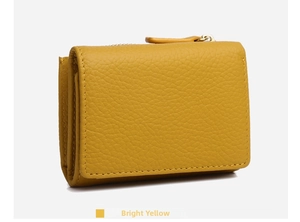 Detail of yellow pebbled leather wallet featuring a zipper coin pocket and fine stitching