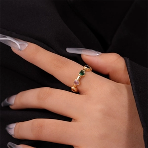 Close-up of gold-plated heart ring featuring multi-colored zircon stones on model's hand