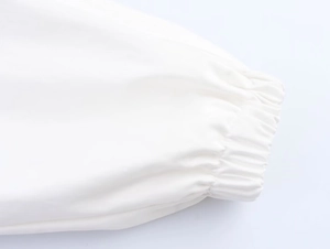 Detail shot of white elastic cuffs on a high-neck utility jacket with smooth windproof fabric