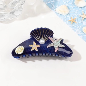 Detail of blue glitter shell hair claw with pearl and starfish rhinestone embellishments