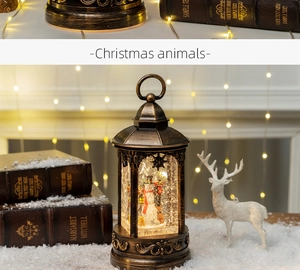 Close-up of retro bronze Christmas lantern with miniature snowman scene and festive LED light