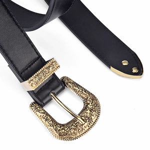 Detail of vintage carved gold buckle and tip on a wide black leather belt for women