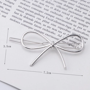 Close-up of a silver bow-shaped hair clip with 7.2cm length dimensions on minimalist card