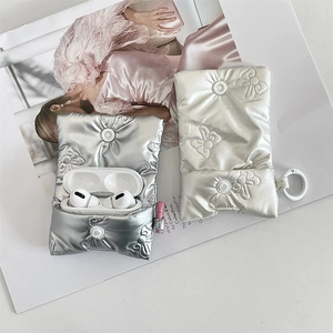 Close-up of quilted bow AirPods case with butterfly embroidery and silver snap closure