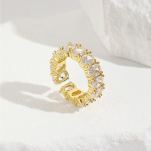Adjustable gold plated copper ring with pave CZ stones on a white marble background