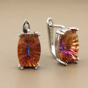 Detailed close-up of rose gold earrings featuring rectangular colorful crystals with iridescence