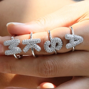 Silver balloon letter rings I K S A with pavé crystals on a hand model
