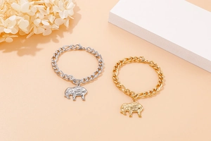 Detailed close-up of gold and silver elephant pendant bracelets with thick link chains