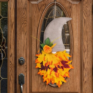 Fall gnome decoration with burlap hat and maple leaf beard hanging on a wooden glass door