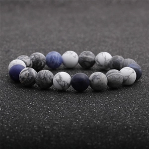 Minimalist sodalite and marble beaded couple bracelet on a textured black background
