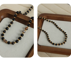 Macro detail of natural agate beads necklace with golden spacers and toggle clasp