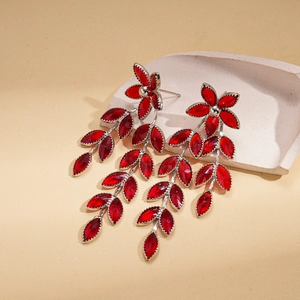 Detail of red flower tassel earrings with leaf-shaped stones and silver metal setting