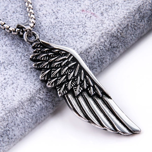 Close-up of vintage titanium steel feather pendant with detailed wing texture and chain