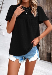 Detail shot of a black textured short sleeve top with lace trim and casual denim shorts