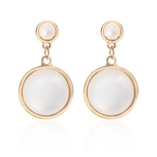 Detailed close-up of gold drop earrings featuring elegant round white pearls and opals