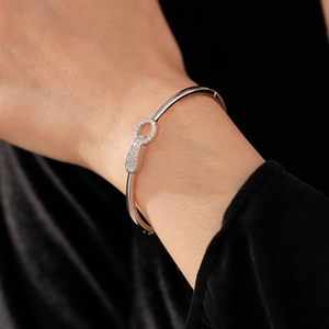 Detailed view of silver-tone horseshoe buckle bracelet with shimmering pave zircons