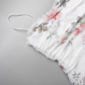 Nahaufnahme eines Blumenkleides mit feiner Spitzenborte und elastischem Faltenstoff