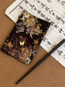 Macro detail of Chinese style brocade fabric with golden butterfly and floral embroidery