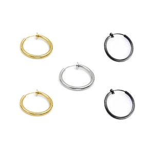 Flat lay of circular clip-on earrings in gold, silver, and black finishes on white