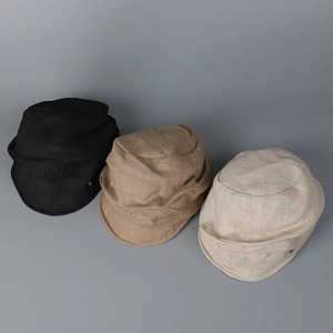 Detail view of cotton linen newsboy caps in black, khaki and beige with metal buttons