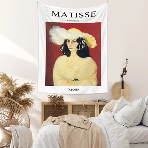 Artistic Henri Matisse tapestry detail on wall above a cozy bed in a warm bedroom