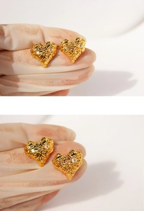 Macro shot of gold heart earrings with molten lava texture and sparkling cubic zirconia
