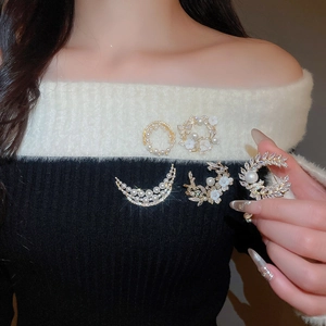 Detailed close-up of 18k gold plated shell flower brooch with pearls and zircons on clothing