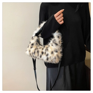 Detail of leopard print plush crescent bag with soft faux fur and black leather strap