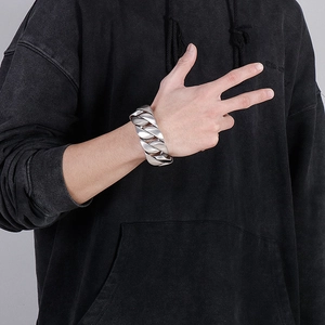 Silver Cuban link bracelet for men in punk style shown on a model's wrist over a sleeve