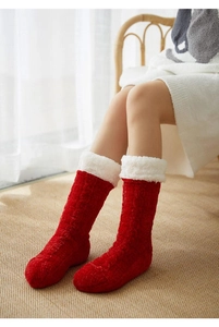 Close-up of red chunky knit winter floor socks with white fuzzy cuffs on model