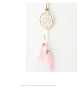 Macro detail of handmade dreamcatcher with pink feathers and wood beads for wall hanging