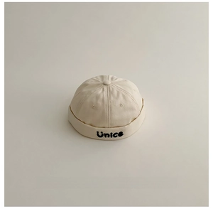 Dettaglio del cappello docker beige per bambini con ricamo Unice e tela premium