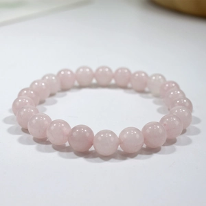 Close-up of natural rose quartz beaded bracelet with polished translucent pink stones
