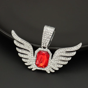 Macro shot of silver angel wing pendant with red rectangle gem and crystal inlay