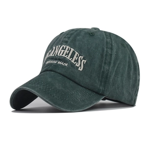 Detailed close-up of dark green washed cotton baseball cap with white vintage embroidery