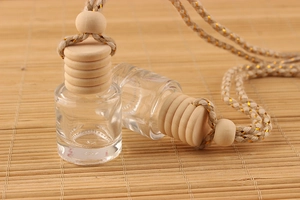 Close-up of 8ml clear glass car perfume hanging bottles on a natural bamboo mat