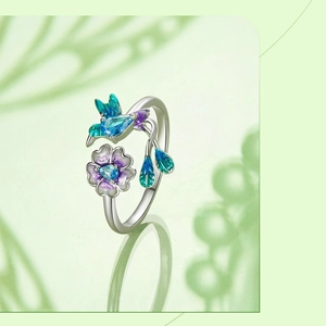 Macro shot of silver hummingbird ring with blue enamel and sparkling crystal details