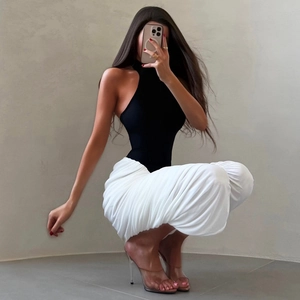 Détail d'un haut licou noir et d'une jupe blanche froncée moulante sur modèle