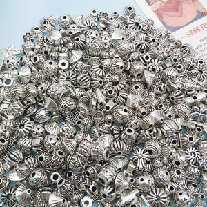 Close-up of antique silver alloy beads with cross, starfish, and shell patterns for DIY