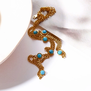 Detailed close-up of natural turquoise beads and zircon tassels on a gold-plated necklace
