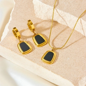 Parure de bijoux minimaliste en acier doré avec pendentifs carrés noirs sur pierre beige